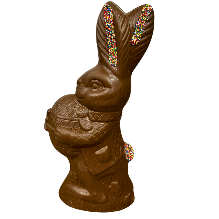 Handcrafted chocolate Easter bunny holding decorated egg with sprinkles from Dolce Confections